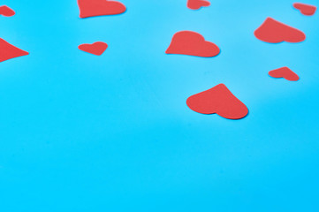 Many scattered red paper hearts on blue background. Concept of Valentines Day. Space for text