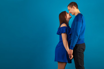Naklejka premium young couple in love on a blue background with red balloons. Valentine's Day