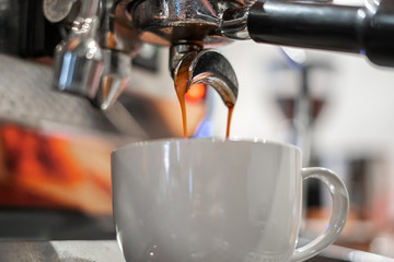 Coffee is poured from a professional coffee machine into a wide Cup.