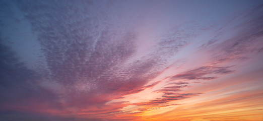 purple orange red pink bright sky at sunset with voluminous multicolored clouds