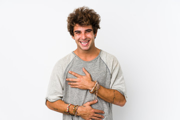 Young caucasian man against a white background isolated laughs happily and has fun keeping hands on...
