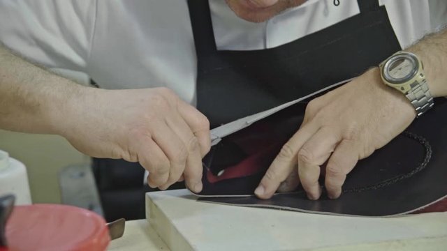 Craftsman gluing and stiching all parts of a upper part of a shoe together. 