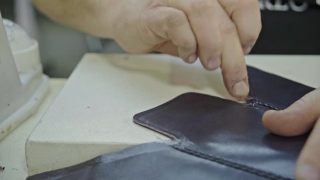 Craftsman gluing and stiching all parts of a upper part of a shoe together. 