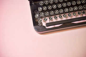 Vintage Black Typewriter Keyboard on Solid Pink Background