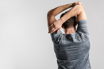 Image from back of young athletic man doing exercise while working out