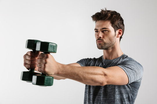 Image of handsome athletic man doing exercise with dumbbells