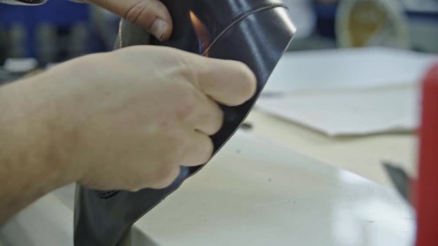 Craftsman gluing and stiching all parts of a upper part of a shoe together. 