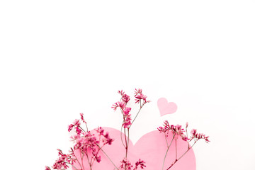 A large pink heart with a place for text decorated with small pink flowers on a white background