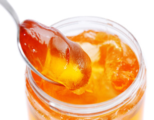 sweet yellow honey food in spoon and glass jar on white background