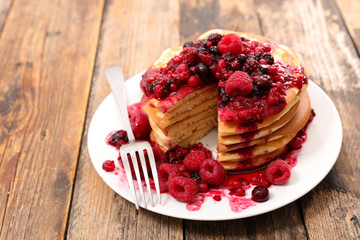 stack of pancakes and berries fruits syrup