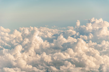 sky seen from an airplane window with lots of clouds and contrasting colors