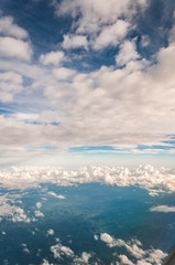 sky seen from an airplane window with lots of clouds and contrasting colors