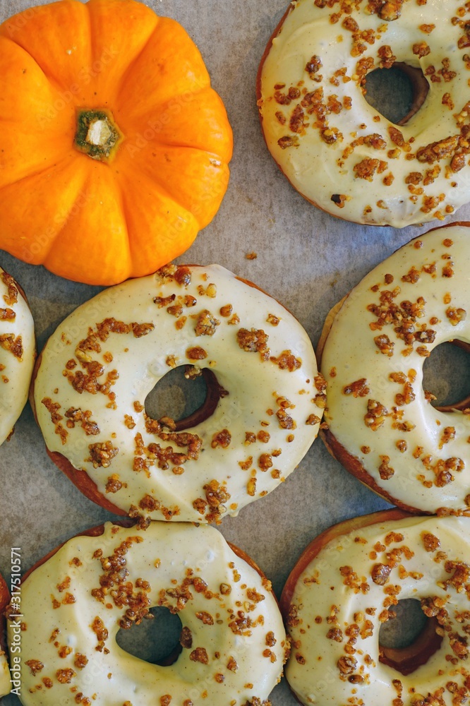 Wall mural fresh pumpkin donuts with white icing