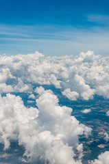 sky seen from an airplane window with lots of clouds and contrasting colors