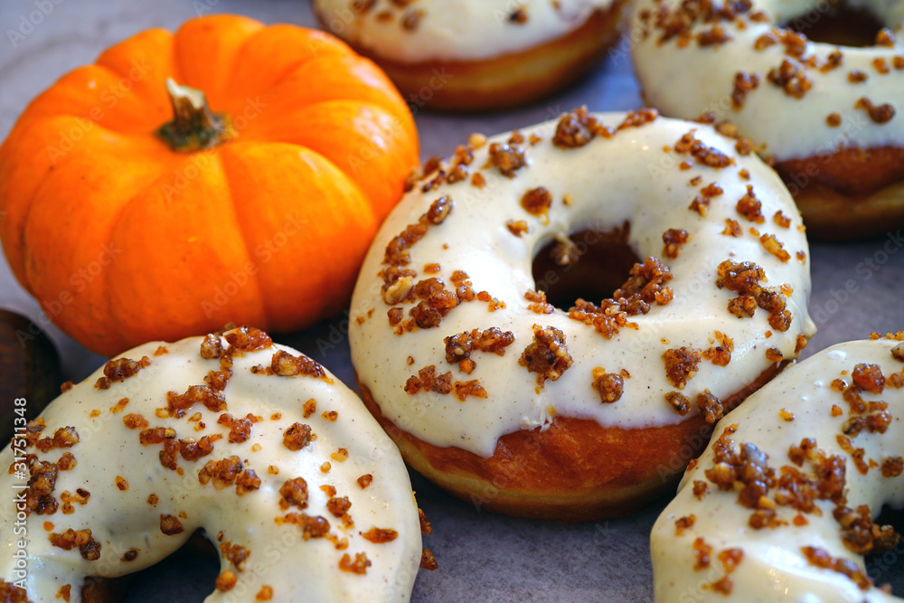 Wall mural Fresh pumpkin donuts with white icing