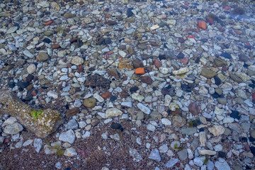 Small beach by the coast covered with multiple stones and sand