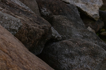 Fototapeta na wymiar Piles of boulders spread all over the coast; Macro texture of granite and sand