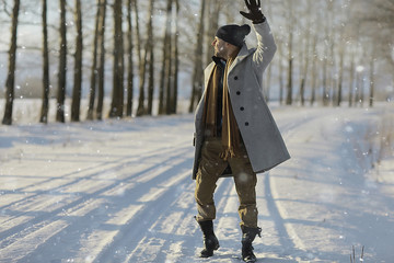fashionable man in a coat / winter style, walk against the backdrop of the winter landscape, snowy weather, warm clothes