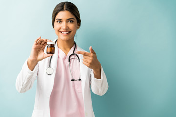 Happy Healthcare Worker With Medicine Bottle In Studio