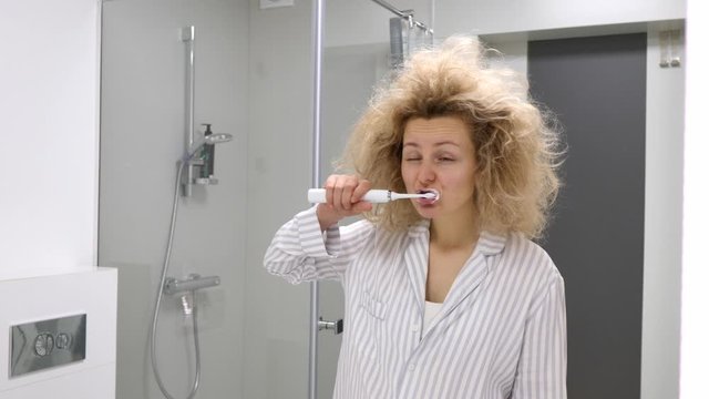 Young Hairy Woman Standing In Front Of Bathroom Mirror And Brushing Her Teeth.