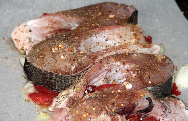 Silver carp fish fillet with spices and red pepper.