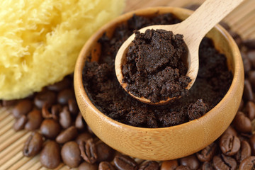 Homemade coffee scrub face mask in wooden bowl with spoon on coffee beans