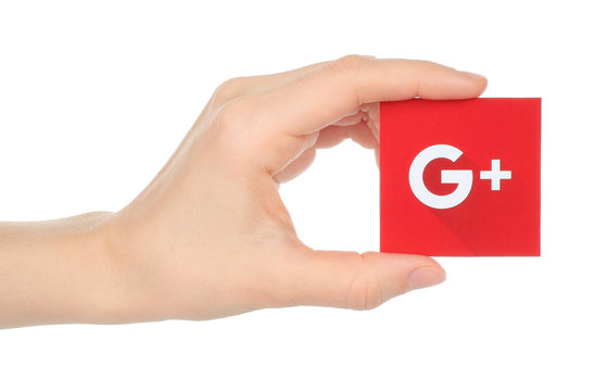 Kiev, Ukraine - January 15, 2016:Hand holds new Google plus logotype printed on paper and cut, on white background.Google is USA multinational corporation.