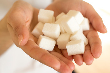 handfull of white sugar cubes on white background