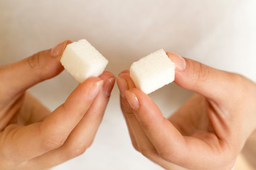 young woman holding white sugar cubes