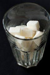 white sugar cubes in a glass on black background