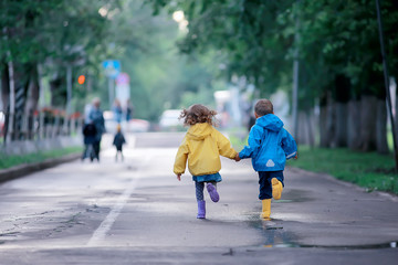 children run in raincoats / summer park, rain, walk brother and sister, children boy and girl