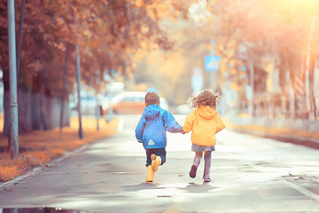 children run in the yellow autumn park rain / fun walk autumn seasonal landscape weather wet