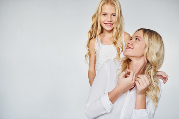 Mother with her daughter have fun together in the studio with white background