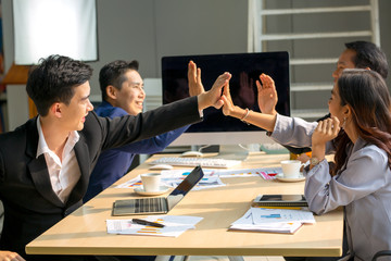 A group of business people are meeting to analyze data for marketing plan and hand shaking or hand share unity