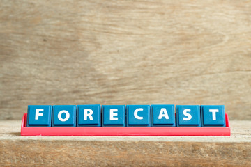 Tile letter on red rack in word forecast on wood background