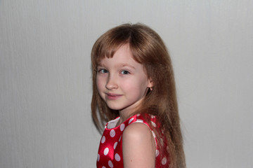 A girl in a red dress with white polka dots. Girl in retro style.