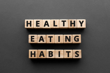 Healthy Eating Habits - words from wooden blocks with letters, healthy eating habits concept, top view gray background