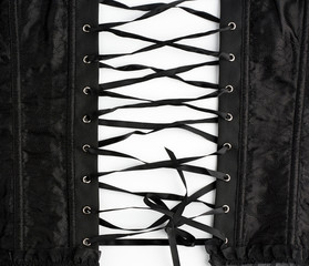 fragment of a black satin corset with lacing, back view