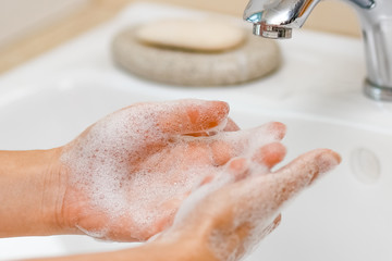 Fototapeta premium Hygiene concept. Washing hands with soap under the faucet with water