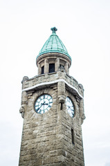 historic harbor in Hamburg with ships and docks in the background and harbor facility with belfry in Germany Europe and vignette