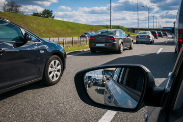 Traffic jam on motorway, front and rear view in car mirror.