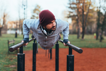 handsome young man jogging outdoors in city park work out in outdoor gym