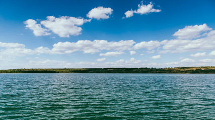 Wide view of the lake. Coast, sky and clouds