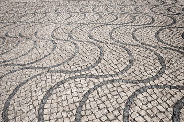 cobblestone pavement with wavy lines, made of granite cubes. black and white