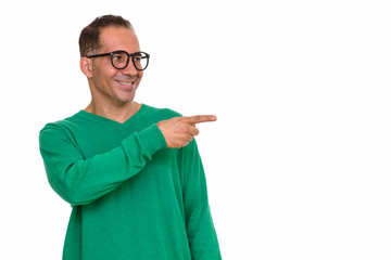 Mature happy Persian man pointing finger on the side