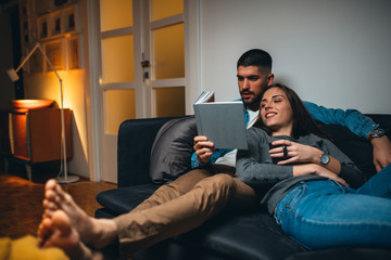 romantic couple reading book at home