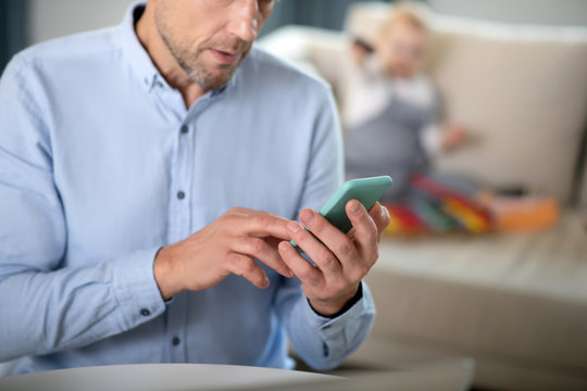 Bearded man in a blue shirt tping a message