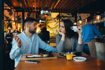 couple arguing in restaurant while having lunch