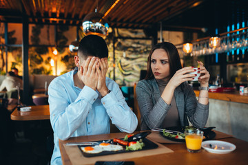 couple arguing in restaurant while having lunch