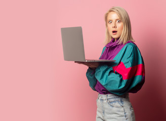 Beautiful blonde woman in 90s clothes with laptop computer